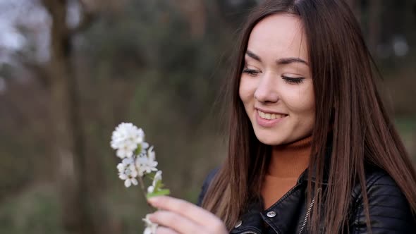 Beautiful Brunette with a White Flower in Her Hands