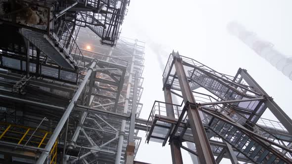 Movement under metal structures. Epic industrial landscape on a foggy cloudy day