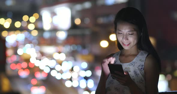 Woman use of smart phone in city at night 