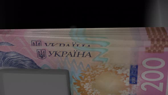 200 Ukrainian hryvnia in cash dispenser. Withdrawal of cash from an ATM.