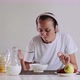 Woman in headphones is listening music while eating cornflakes with milk. - VideoHive Item for Sale