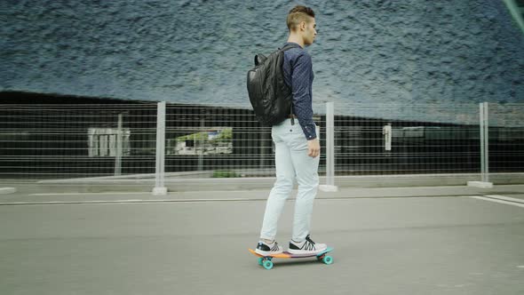 Well-Dressed Entrepreneur businessman Portrait of a Young Attractive Trendy Man skateboarding on a s