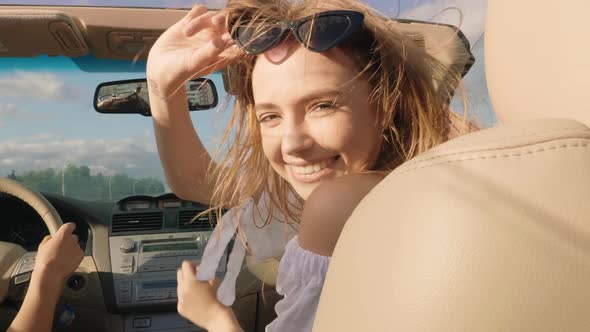 Young beautiful and smiling hipster girl in convertible car