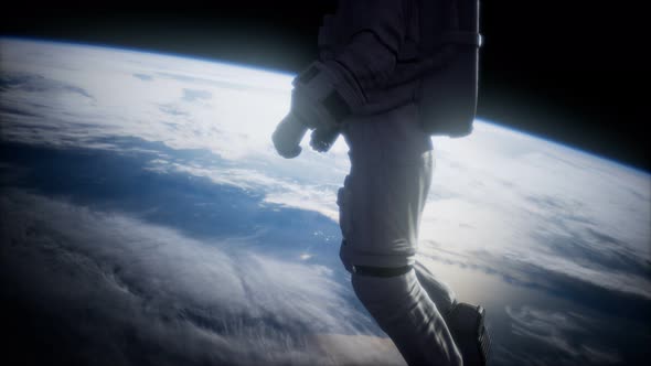 Astronaut in Outer Space Against the Backdrop of the Planet Earth alt