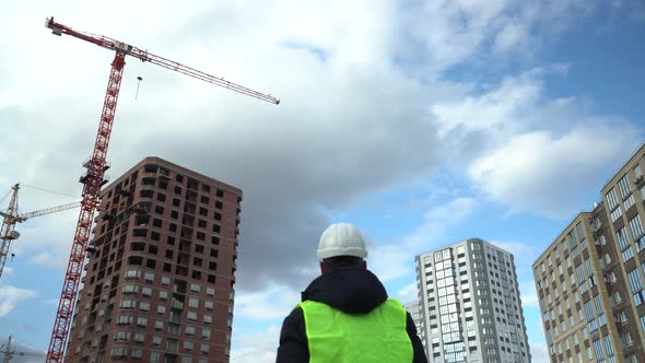 Consulting Engineer at Construction Site Holding Blueprint in Hand