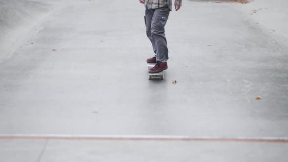 Skater Practicing in the Autumn Concrete Skate Park Making Tricks and Rides in Ramp