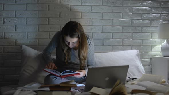 Female Student Reading Books, Typing Project on Laptop Late at Night, Deadline