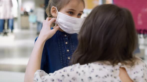 Mother putting a medical mask on her lovely daughter's face. Shot with RED helium camera in 8K.