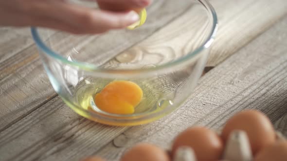 Woman Chef's Hands Break A Chicken Egg To Make Waffle Dough. Breaking The Egg Into A Transparent
