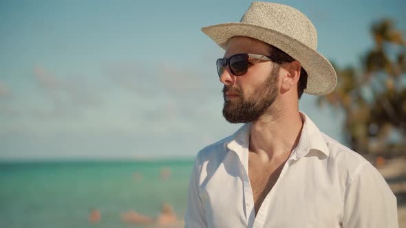 Man Walking On Tropical Beach. Guy Relaxing On Caribbean Beach. Tanned Man In Hat Healthy Skin.