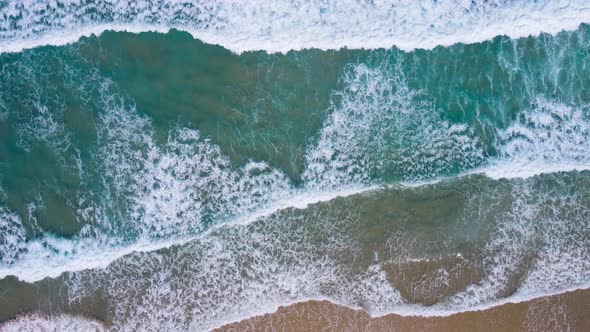 Aerial view Top view of seawater wave in nature on sandy beach. In sunset time. Summer beach sea