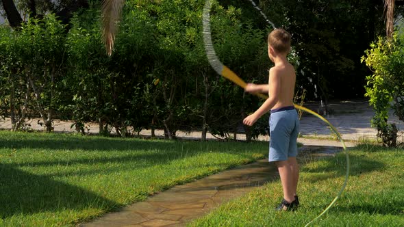 Child Having Fun When Watering Lawn with Hose