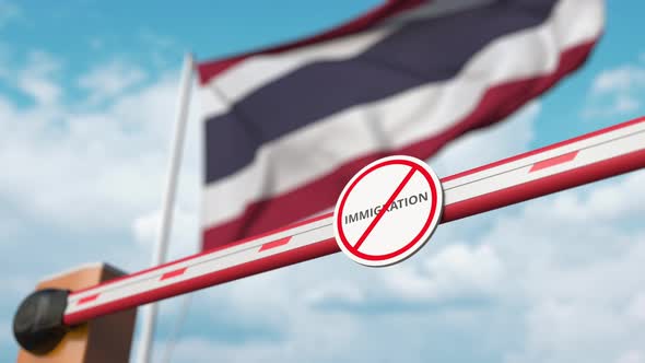 Opening Barrier with Stop Immigration Sign Against the Thai Flag