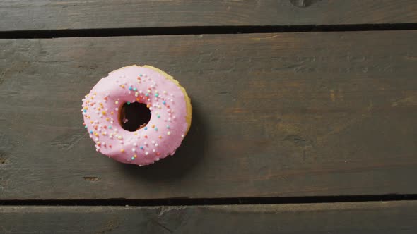 Video of donut with icing on wooden background