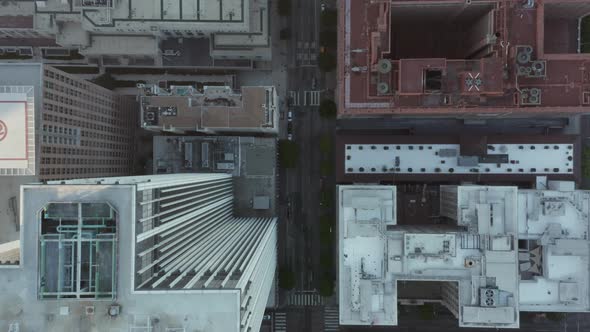 Slow Aerial Drone View of City Street with Skyscraper Rooftops and Road Traffic Birds Eye Overhead