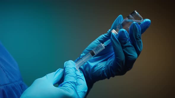 Doctor Filling Syringe with Solution on Blurred Background