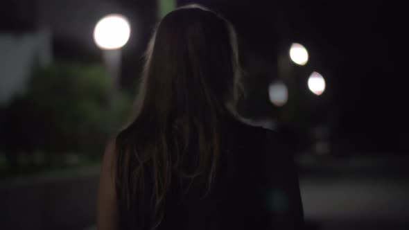 Woman walking alone in night street
