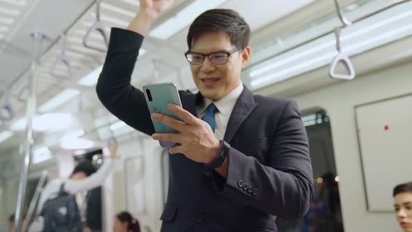 Businessman Using Mobile Phone on Public Train
