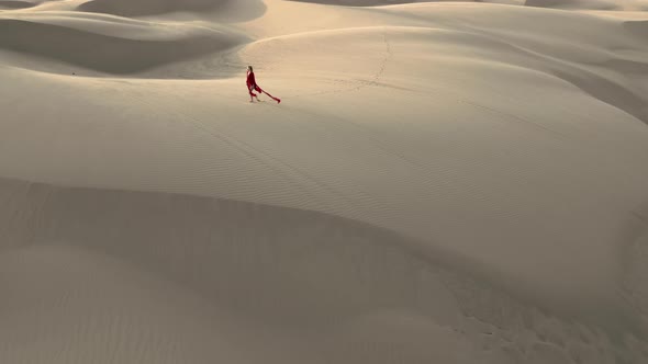  Distant Drone View of a Model Walking By Sand Dunes at the Desert Nature, USA