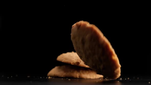 Stack of cookies falling on table.