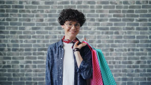 Portrait of Joyful Girl Shopaholic Holding Shopping Bags Looking at Camera