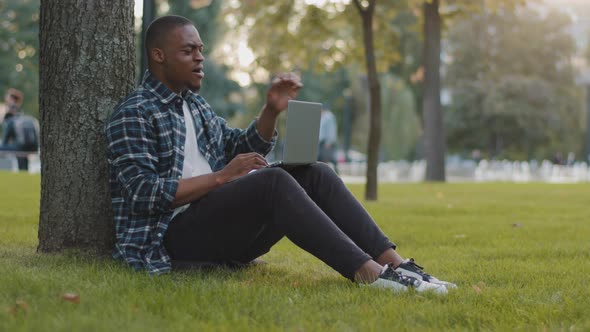 Tired Student Guy Bored Male African American Business Man Freelancer Sitting on Green Grass Lawn in