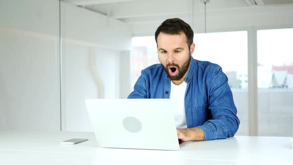 Amazed Man Working on Laptop in Shock