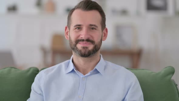 Young Man Smiling at Camera at Home