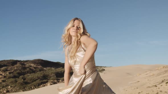 Beautiful Woman In Gold Dancing On Beach