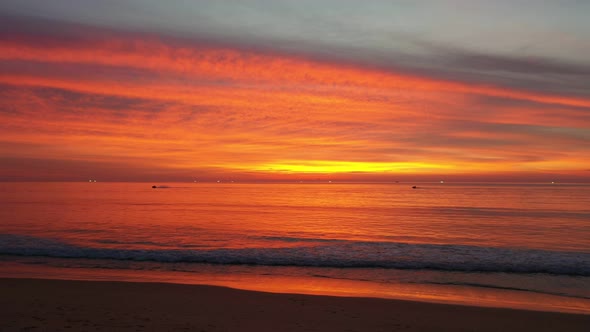 Smooth Waves In Bright Red Sky At Twilight.