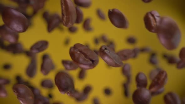 Super Closeup of the Roasted Coffee Beans Rotating on the Yellow Background