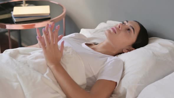 Pensive Latin Woman Laying Awake in Bed