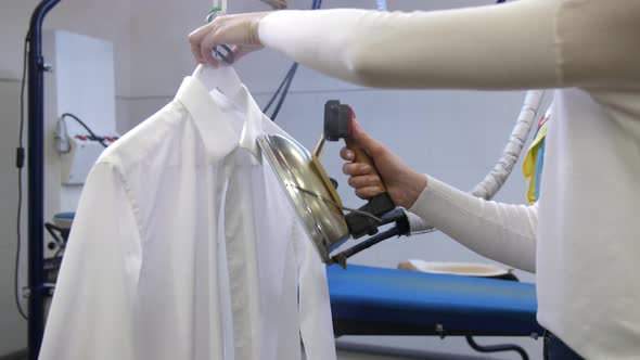 Steam Ironing of White Man's Shirt in Dry Cleaning