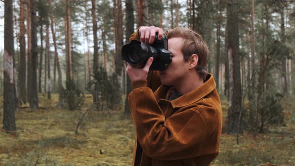 A Young Blond Photographer Takes Pictures in the Woods