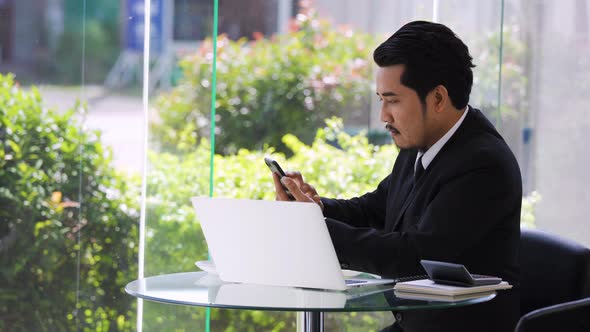 young business man working with smartphone and laptop computer