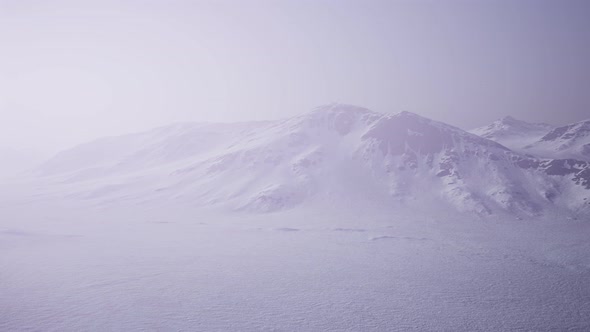 Aerial Landscape of Snowy Mountains and Icy Shores in Antarctica