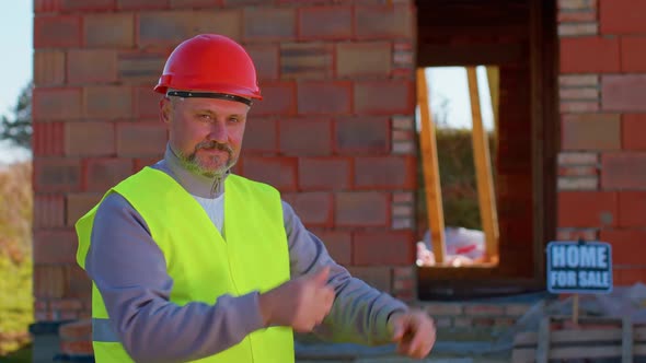 Engineer Architect Looking Approvingly at Camera Showing Thumbs Up Recommending Buying a House