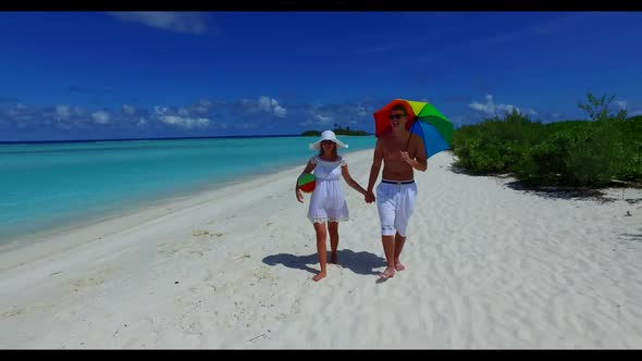 Romantic couple in love on marine shore beach break by clear ocean and white sandy background of the