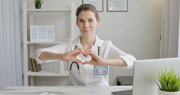 Doctor Shows Heart. Therapist Makes Hand Gesture Things I Love You. Woman in Medical Coat Shows