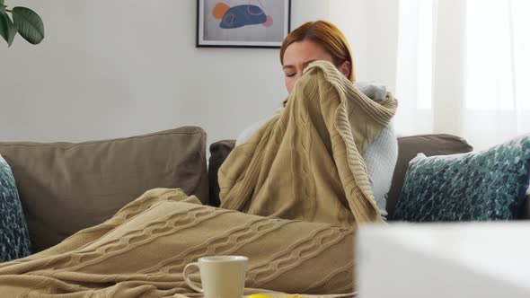 Sick Woman in Scarf Wrapping Into Blanket at Home