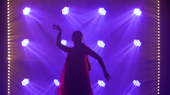 Silhouette a Young Girl Dancer in a Red Sari. Indian Folk Dance. Shot in a Dark Studio with Smoke