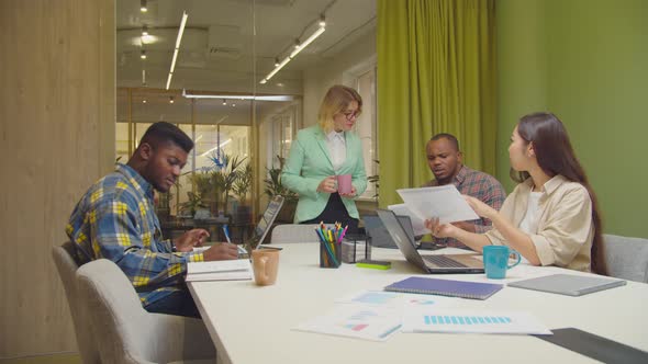 Businesswoman Explaining Working Tasks To Team