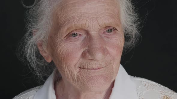 Close Portrait of Wrinkled Cute Grandmother with Sadness in Eyes