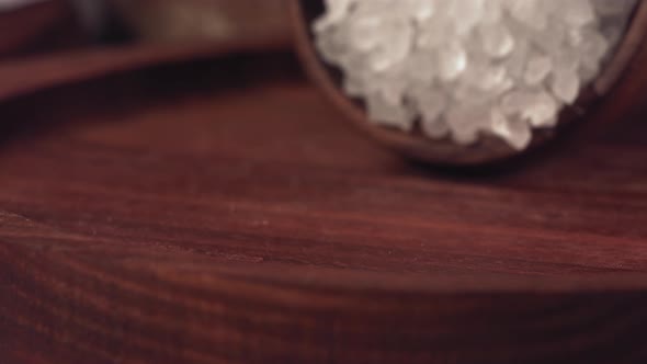 Salt Falling on a Wooden Table with Black Pepper