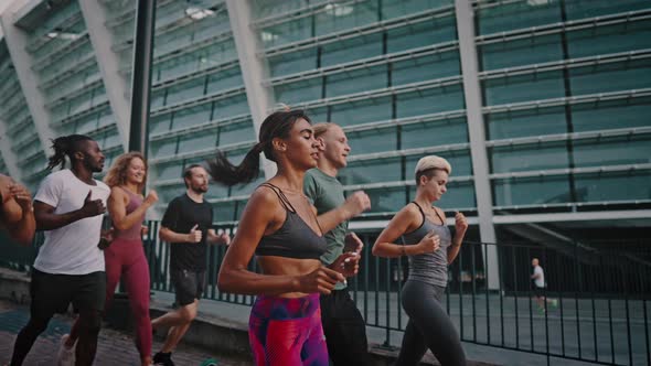 Group of Young Athletes are Jogging Before the Start of the Big Marathon