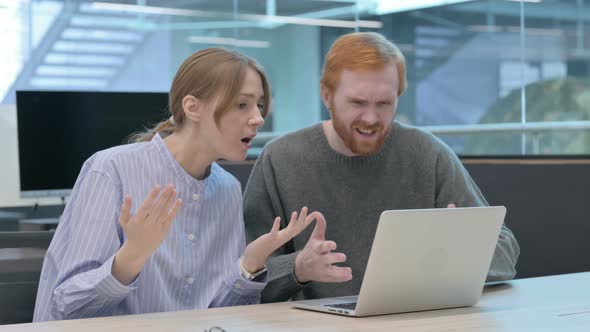 Young Man and Woman Reacting to Loss on Laptop