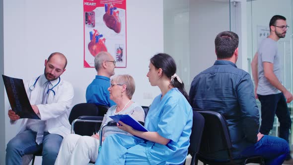 Medical Staff Discussing Diagnosis with Disabled Senior Woman