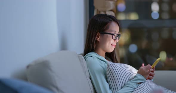 Woman with glasses and use of mobile phone at home