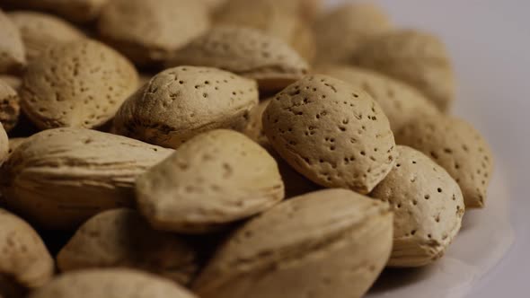 Cinematic, rotating shot of almonds on a white surface - ALMONDS