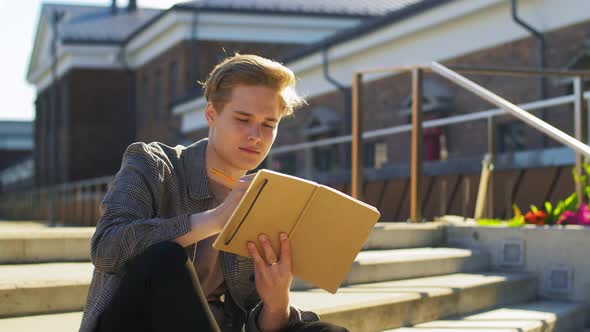 Young Man with Notebook or Sketchbook on Roof Top